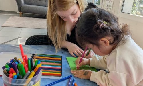Leiterin von Tiny Hands Creations zeichnet gemeinsam mit einem Kind im Atelier in Zürich