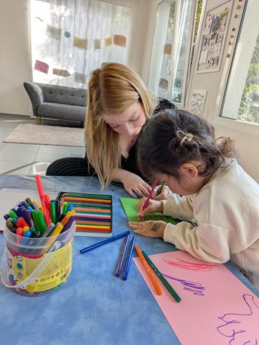 Leiterin von Tiny Hands Creations zeichnet gemeinsam mit einem Kind im Atelier in Zürich