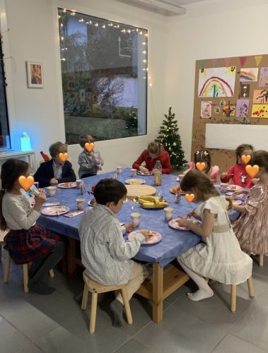 Neun Kinder sitzen am Tisch und essen Kuchen bei einer Märchenland-Geburtstagsparty im Atelier von Tiny Hands Creations